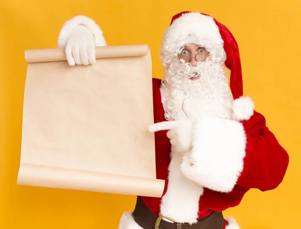 Santa Claus mostrando en la lista de deseos con espacio de copia para el texto — Foto de Stock