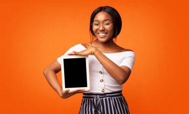 Siyah Kız Tablet Ekranını Turuncu Arkaplan Üzerinde Gösteriyor, Model
