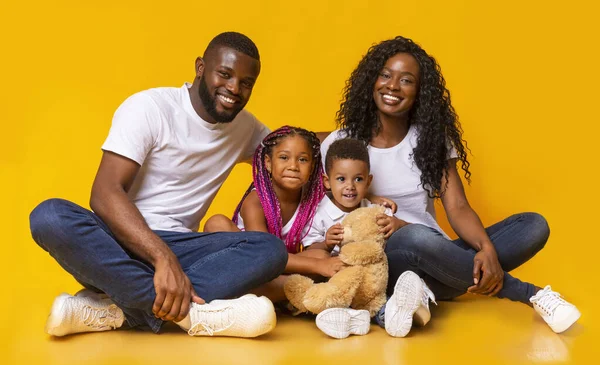 Afro familie met dochter en zoon zitten samen op de vloer — Stockfoto
