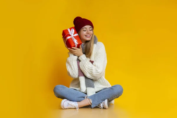 Peaceful woman sitting on floor and holding gift — Stock Photo, Image