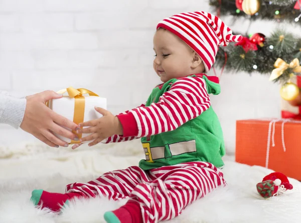 Adorable baby boy in elf costume getting Christmas gift — Stock Photo, Image