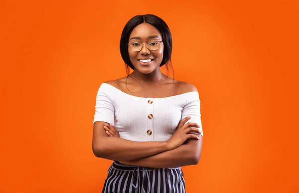 Millennial Afro Girl lächelt vor orangefarbenem Hintergrund in die Kamera — Stockfoto