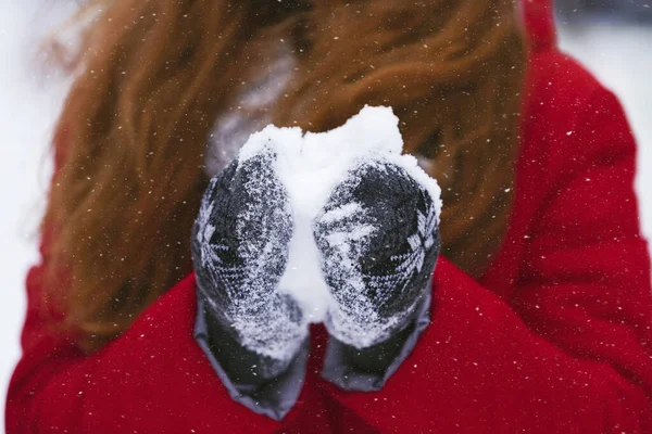 Imagen recortada de niña sosteniendo bola de nieve con guantes calientes —  Fotos de Stock