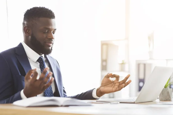 Zwarte zakenman mediteren op kantoor, ontspannen tijdens het werk — Stockfoto