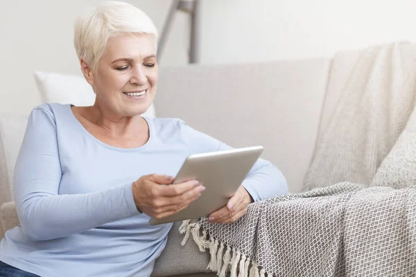 Feliz anciana usando tableta digital en casa — Foto de Stock