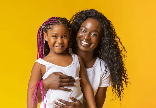 Feliz preto mãe abraçando ela adorável pouco filha — Fotografia de Stock