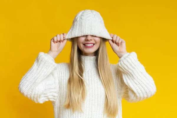 Glimlachende vrouw trekken naar beneden witte wollen hoed — Stockfoto