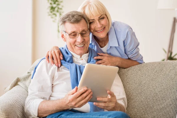 Sonriente pareja madura hablando por videollamada en la tableta — Foto de Stock