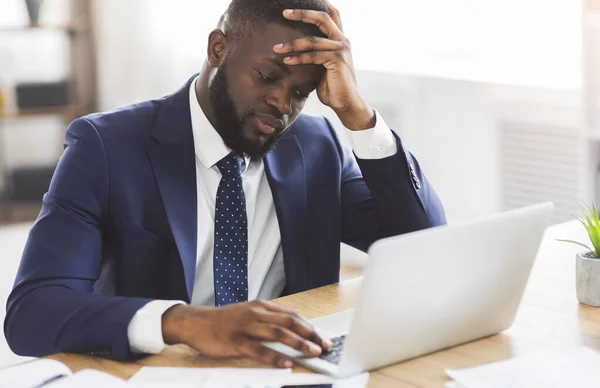 Depressieve man zittend voor laptop op de werkplek — Stockfoto