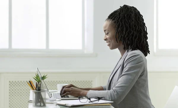 Negocio afro positivo que trabaja en el ordenador portátil en oficina — Foto de Stock