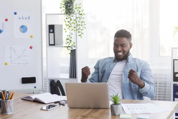 Экстатичный афроамериканский сотрудник радуется успеху бизнеса на рабочем месте в офисе — стоковое фото