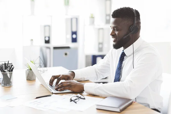 Gelukkige kantoormedewerker helpt klanten, met behulp van laptop — Stockfoto