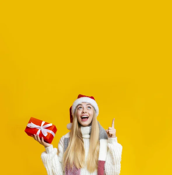 복사 공간을 가리키는 선물 상자를 들고 흥분 한 금발 소녀 — 스톡 사진