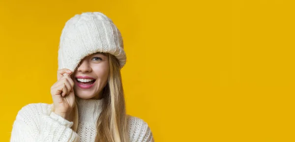 ポートレートの女の子で冬の帽子イマラチオ上の黄色の背景 — ストック写真