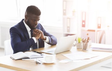 Bulmaca yöneticisi laptop ekranına bakıyor, iş sorunları çözülüyor