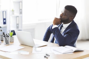 Düşünceli iş adamı iş yerinde iş çözümleri üretiyor.