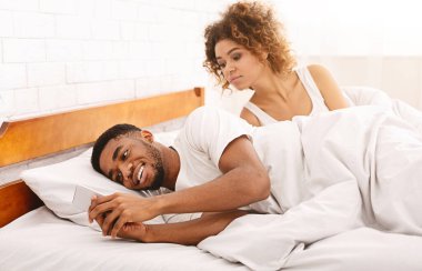 Aldatan Afrikalı bir adam aile yatağında kusur bulmakla meşgul.