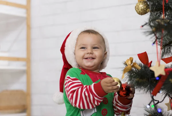 Adorable elfo bebé jugando con decoraciones en el árbol de Navidad —  Fotos de Stock