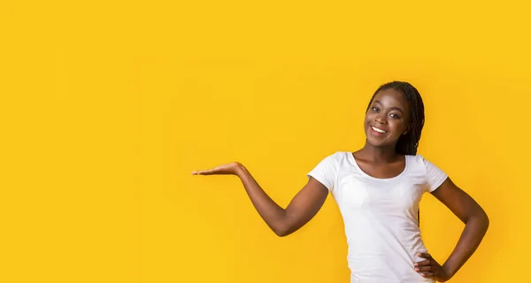Симпатичная черная девушка, указывающая рукой на пустое место — стоковое фото