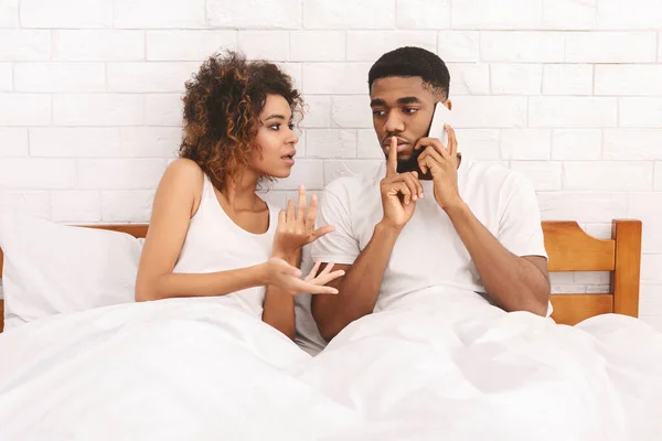 Joven hombre hablando por teléfono celular, ignorando a su joven esposa caliente — Foto de Stock