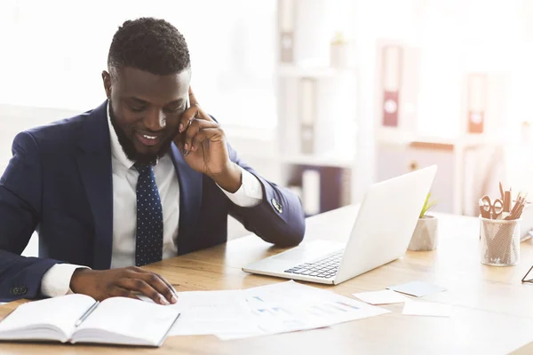 Afro pengusaha memeriksa penelitian pemasaran, berbicara melalui telepon dengan asisten — Stok Foto