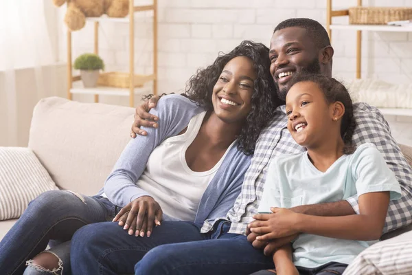 Padre, madre e hija viendo la televisión juntas, relajándose en casa —  Fotos de Stock