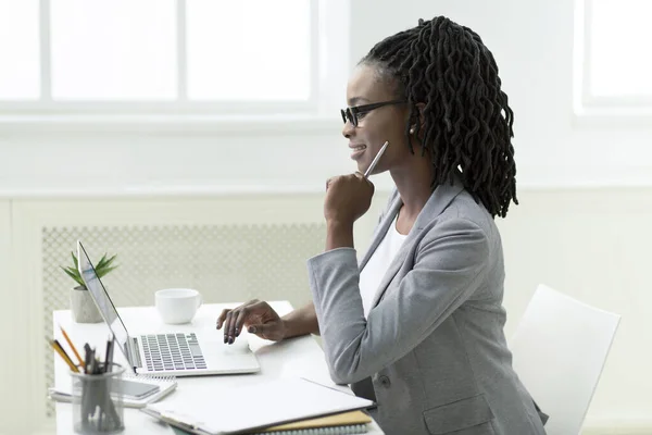Mujer de negocios afro sonriente usando el ordenador portátil trabajando en la oficina — Foto de Stock