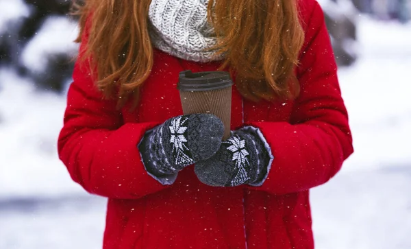 Mujer sosteniendo taza de papel con bebida caliente sobre fondo de invierno —  Fotos de Stock