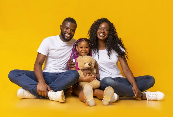 Schattig klein meisje houden teddy beer en poseren met ouders — Stockfoto