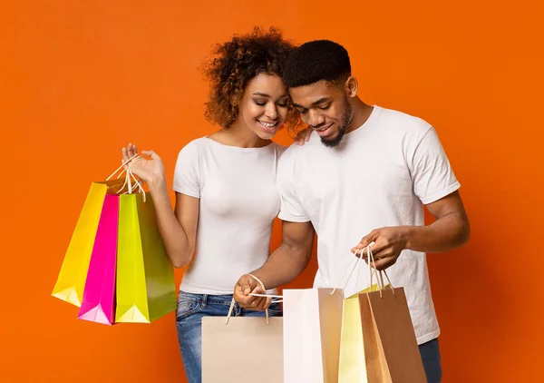 Opgewonden Afrikaanse man en vrouw genieten van hun nieuwe aankopen — Stockfoto