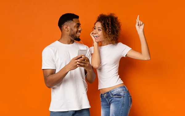 Junges schwarzes Paar genießt Lieblingsmusik auf dem Handy — Stockfoto