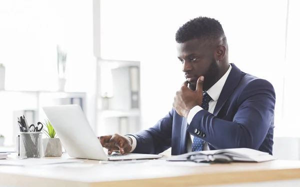 Bedachtzame jonge manager maakt online onderzoek, met behulp van laptop — Stockfoto