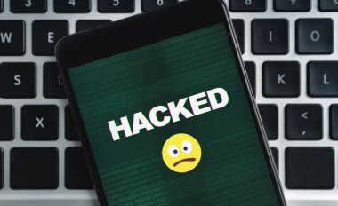 Hacklenmiş yazı ve üzgün emoji simgesiyle akıllı telefon ekranda