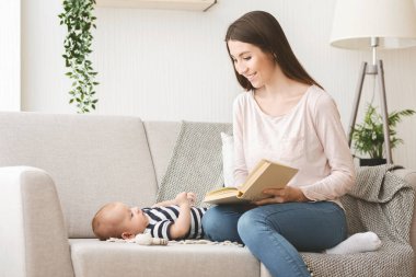 Sevgi dolu anne yeni doğan bebeğine masal okuyor..