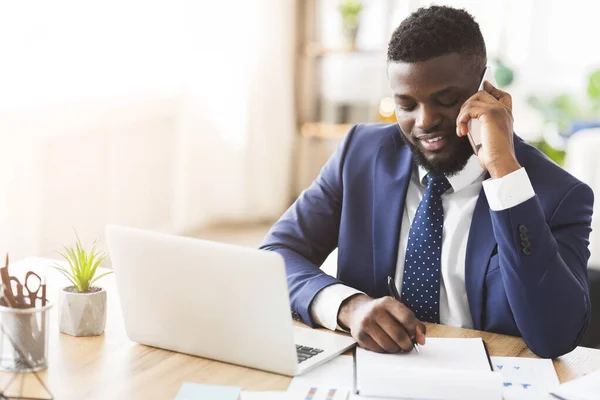 Homme d'affaires souriant parlant par téléphone avec le secrétaire, écrivant des notes — Photo