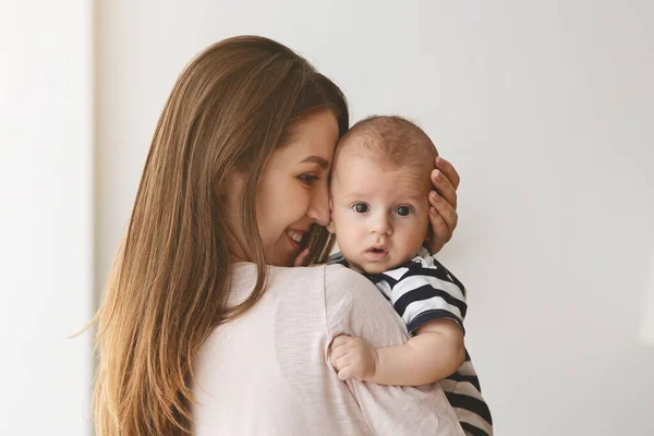 A gyönyörű, fiatal anya portréja, amint kisfiát öleli magához. — Stock Fotó