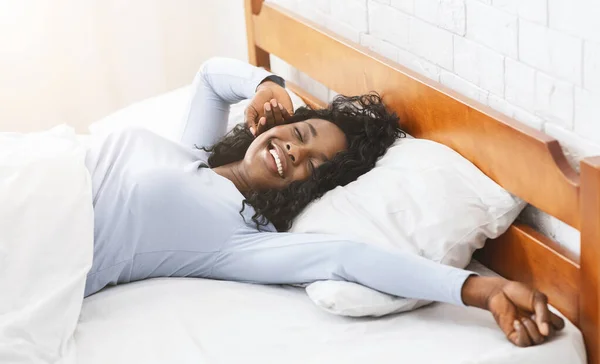 침대에 늘어져 미소짓고 있는 아프리카 소녀 — 스톡 사진
