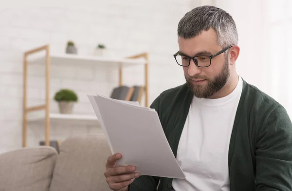 Uomo concentrato leggere articolo stampato, educazione a casa — Foto Stock