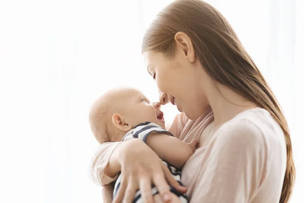 Mutlu anne küçük bebeğiyle burunlarına dokunuyor. — Stok fotoğraf