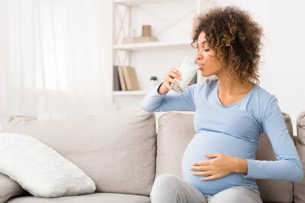 Těhotná žena pije sklenici mléka, těší zdravý nápoj — Stock fotografie