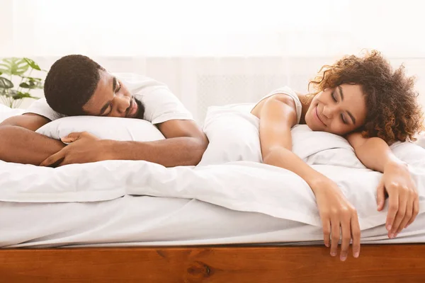 Felizmente cansado amante africano descansando en la cama juntos —  Fotos de Stock