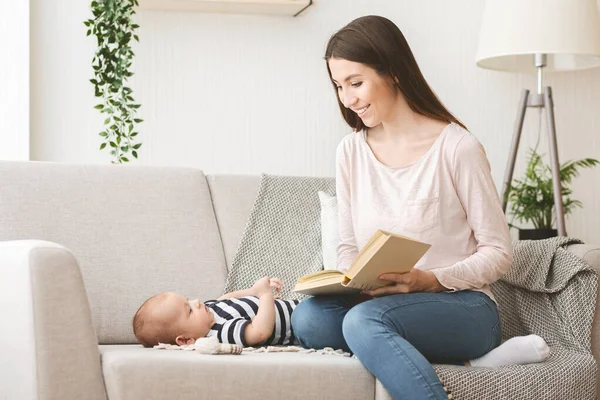 Madre cariñosa leyendo cuento de hadas a su bebé recién nacido . —  Fotos de Stock