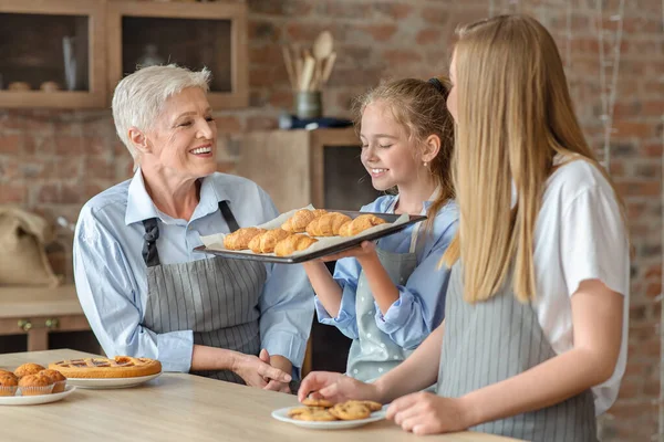 Joyful meisje houden en ruiken vers gebakken croissants — Stockfoto