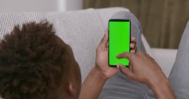 Krom ekran ile cep telefonunda gezinen Afrikalı adam