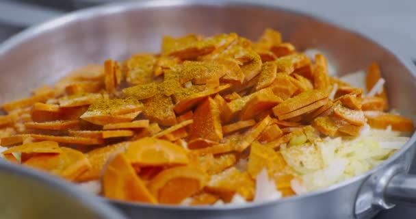 Смесь нарезанной моркови и белого лука на горячей сковороде — стоковое видео