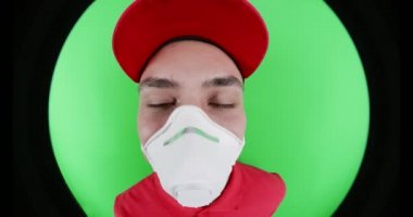 Koruyucu maskeli kurye kapı gözetleme deliğine bakıyor.