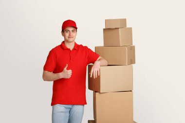 Teslimatçı, karton kutulara yaslanarak işaret dilini iyi kullanır.
