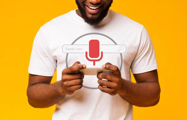 African Guy Using Voice Search On Smart Phone, Yellow Background