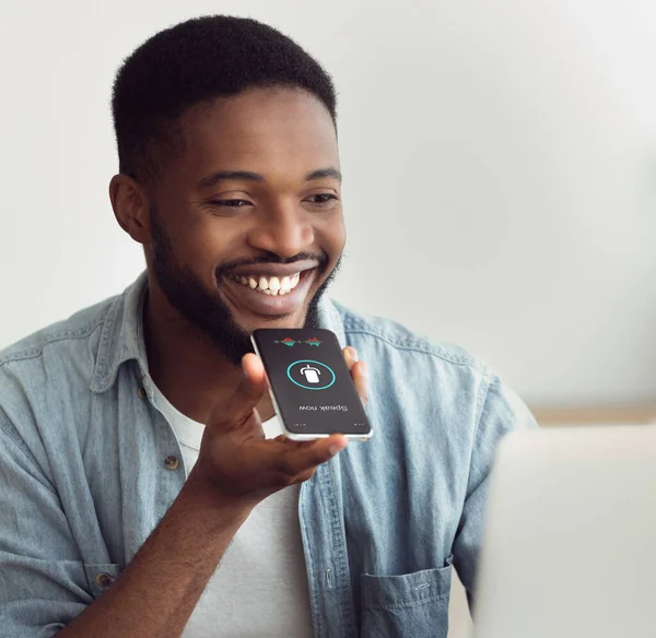 Чорний хлопець використовує розумний телефон помічник голосу сидить вдома — стокове фото