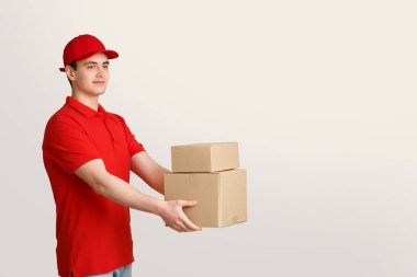 Teslimatçı, postacı ve nakliye konsepti. Üniformalı kurye kutuları elinde tutuyor.